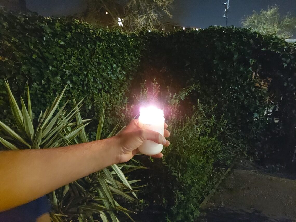 artificial candle and hand at night